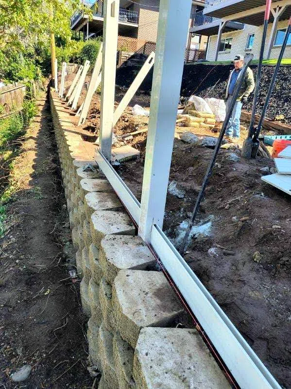 Block retaining wall under construction with drainage in place