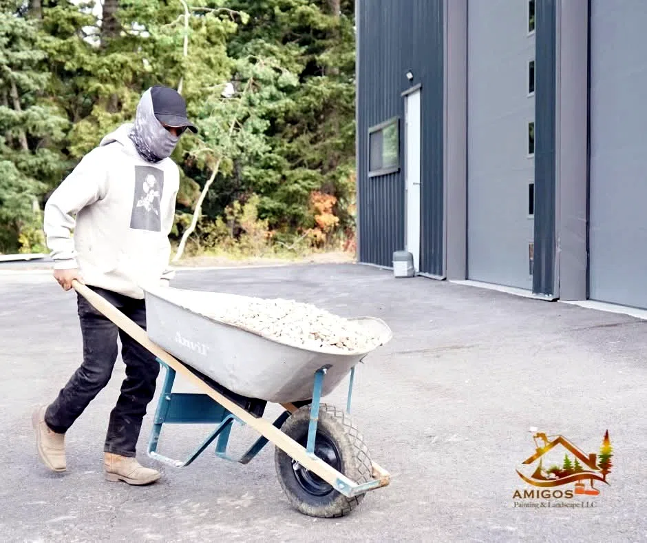 Crew member hauling material by wheelbarrow at a commercial property