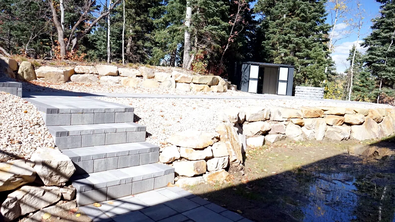Block steps and boulder edging beside a stream at a Wasatch County property