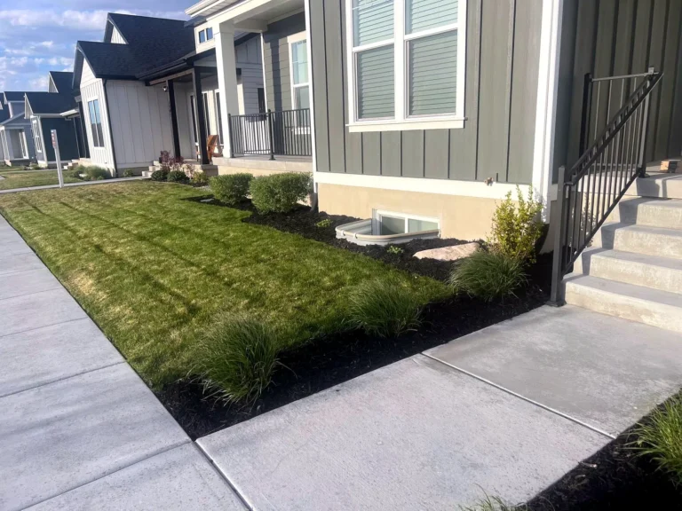 Finished front yard landscape installation in Heber City, Utah with fresh lawn and new planting beds