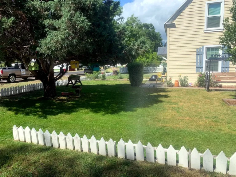 Sprinkler system running across a green lawn on a Heber Valley property