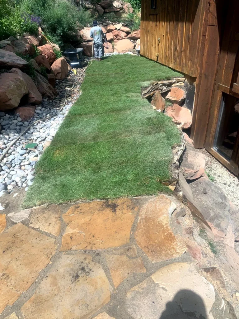 Flagstone patio bordered by fresh sod and stone edging