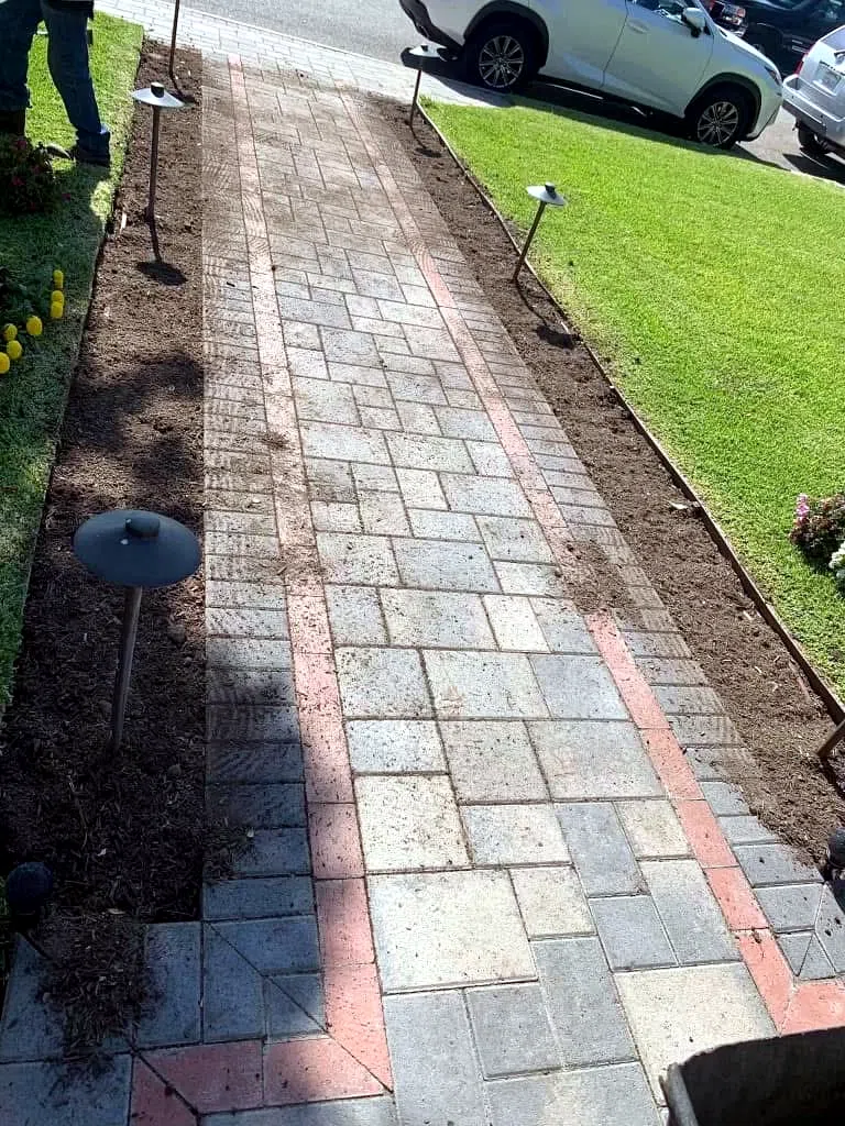 Paver walkway with red and charcoal banding leading to a front door