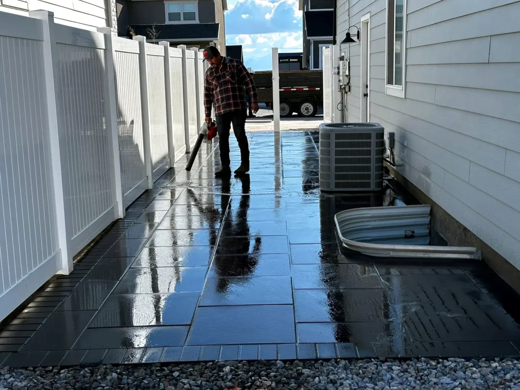 Large-format dark paver walkway running alongside a home