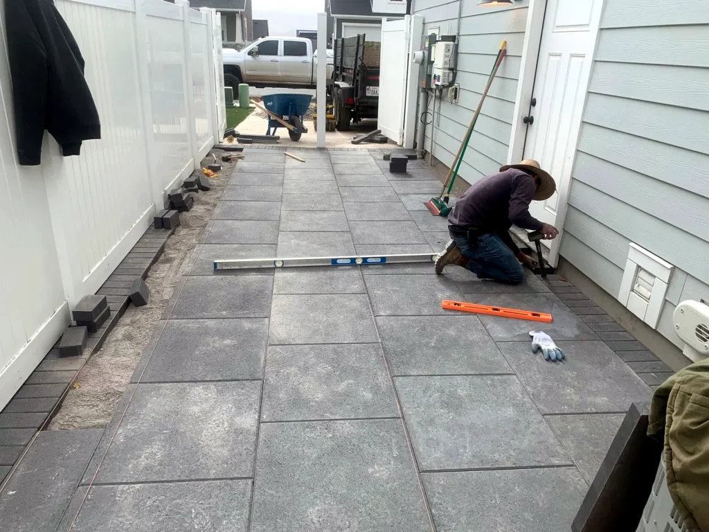 Crew screeding and setting large-format pavers on a prepared base